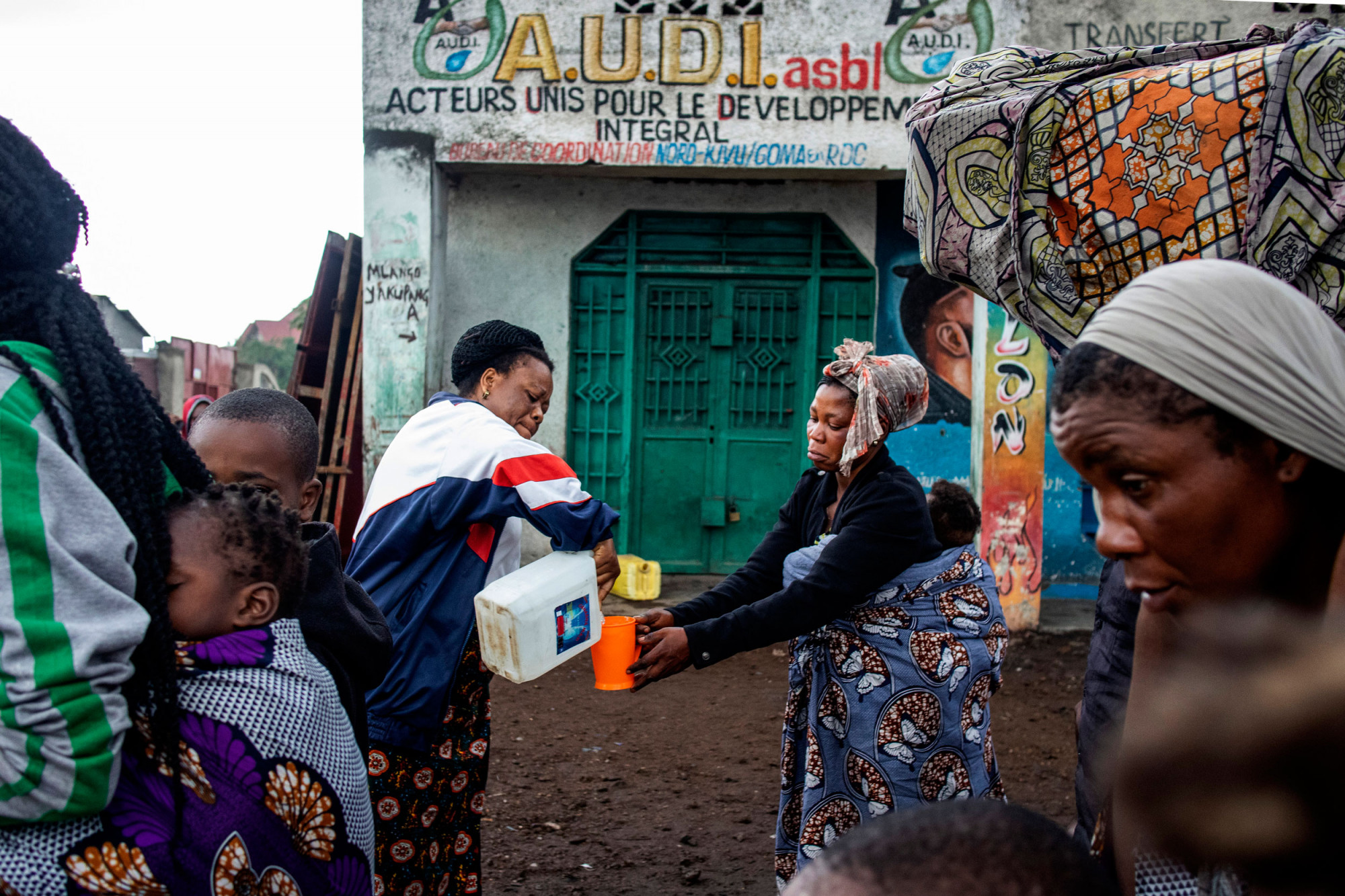 Goma, Nord-Kivu, 23 mai 2021. Au matin suivant l’éruption, on donne à boire à une femme qui fuit la ville. © Arlette Bashizi pour la Fondation Carmignac 