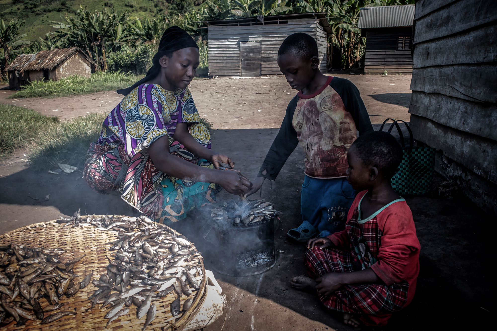 Minova, Nord-Kivu, RDC, décembre 2020. Une femme prépare des sambaza, petits poissons séchés, sur sa cuisinière à charbon de bois. © Guerchom Ndebo pour la Fondation Carmignac 