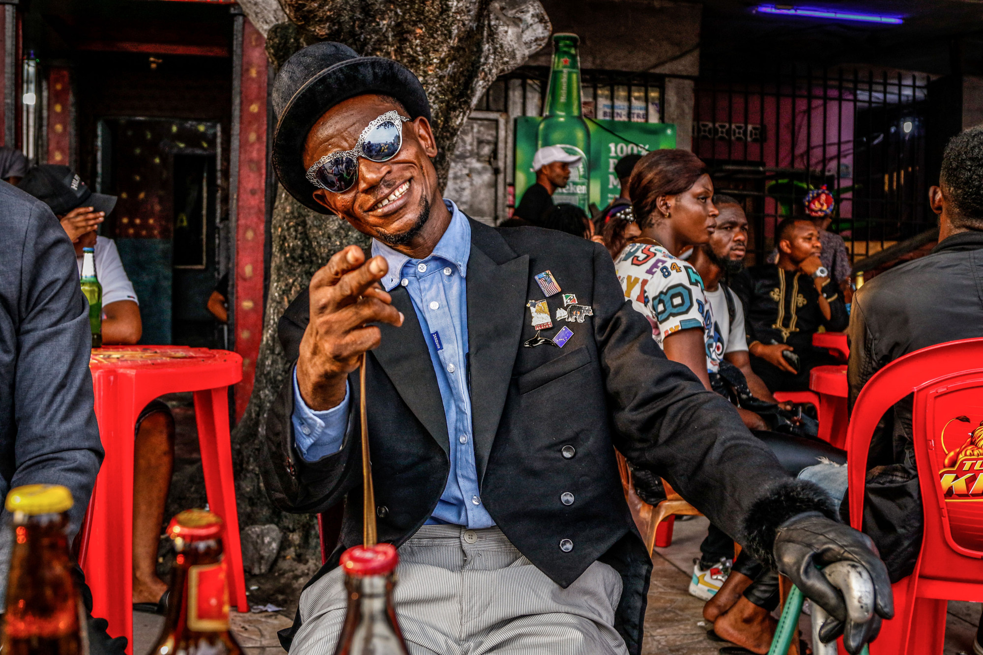 Kinshasa, DRC, February 2021. After gathering at the cemetery the sapeurs moved through town to visit bars in the Matonge neighbourhood. © Justin Makangara for Fondation Carmignac