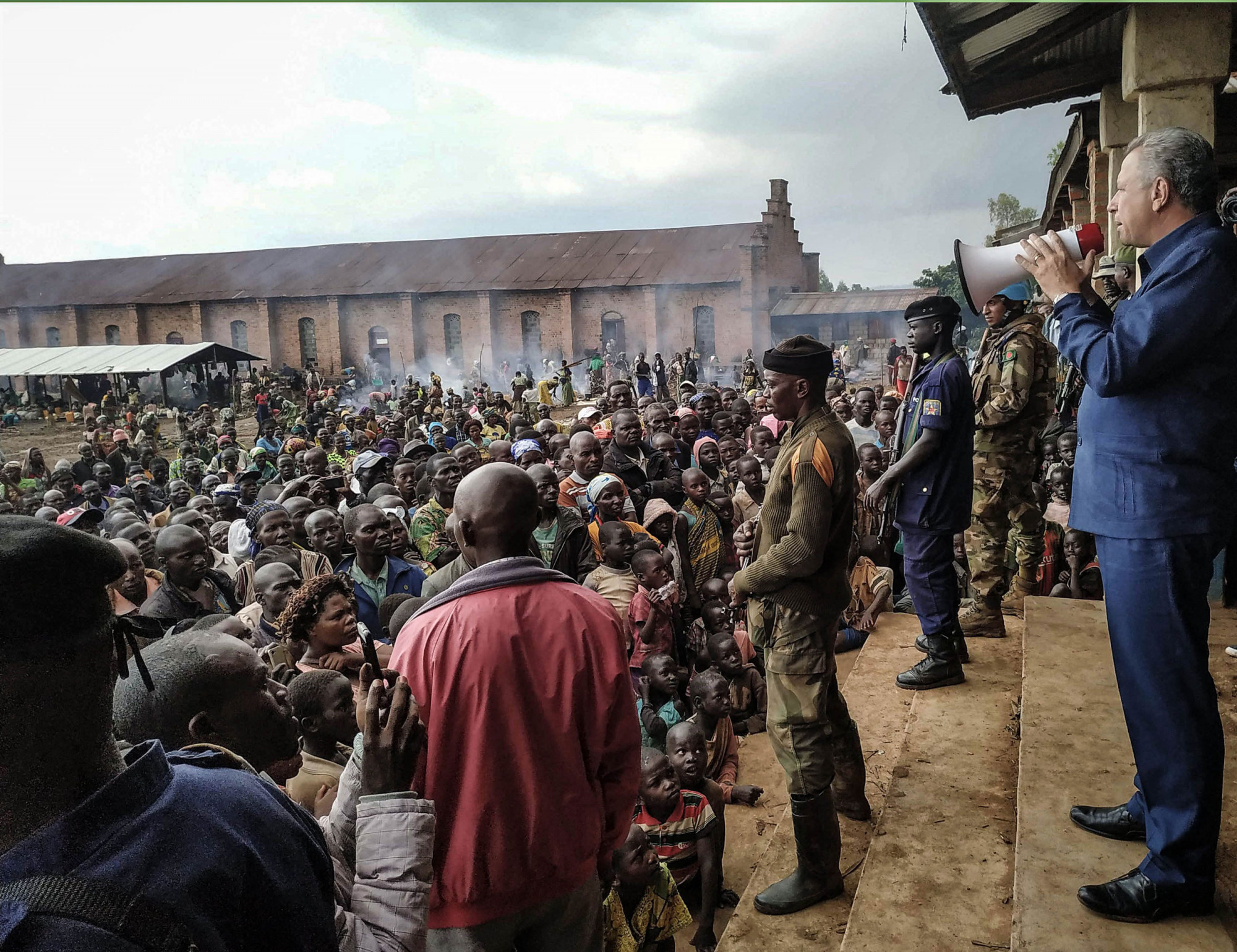 Drodro, DRC, June 2019. The governor of Ituri province, Jean Bamanisa Saidi (right), addresses a crowd of displaced people in the town of Drodro last year after a series of massacres in villages in Djugu territory killed 161 people. © From the archive of Dieudonne Dirole for Fondation Carmignac