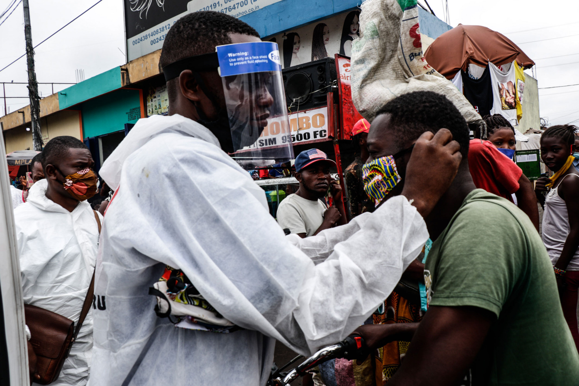 Kinshasa, RDC, mai 2020. Des membres du mouvement citoyen pour la démocratie Filimbi (« sifflet » en swahili) mènent une campagne d’information sur le coronavirus dans un marché de la capitale. © Justin Makangara pour la Fondation Carmignac