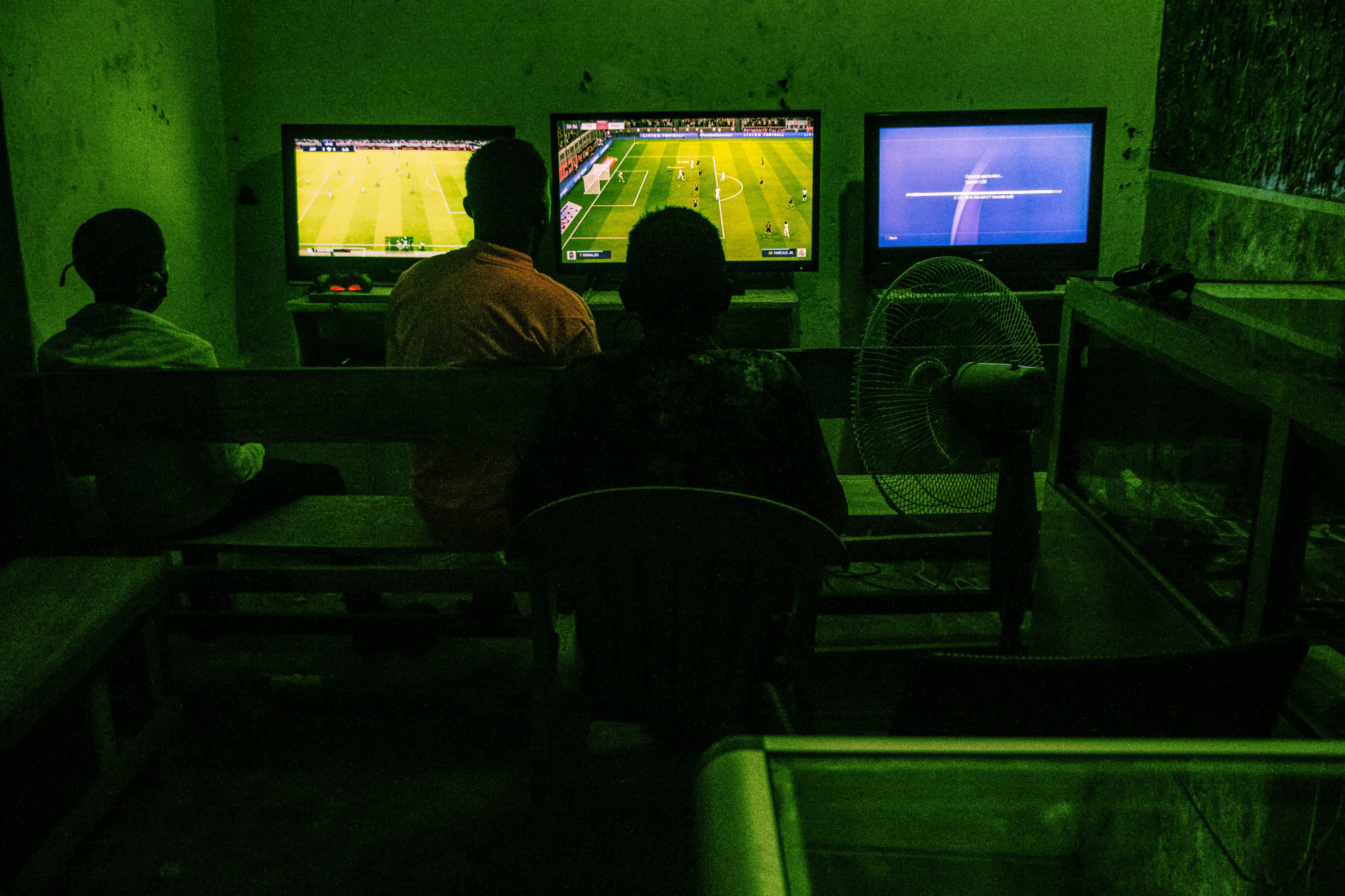 Kinshasa, RDC, mai 2020. Dans le kiosque local alimenté par générateur, des jeunes privés d’électricité à la maison jouent à des jeux vidéo tard dans la nuit. © Justin Makangara pour la Fondation Carmignac