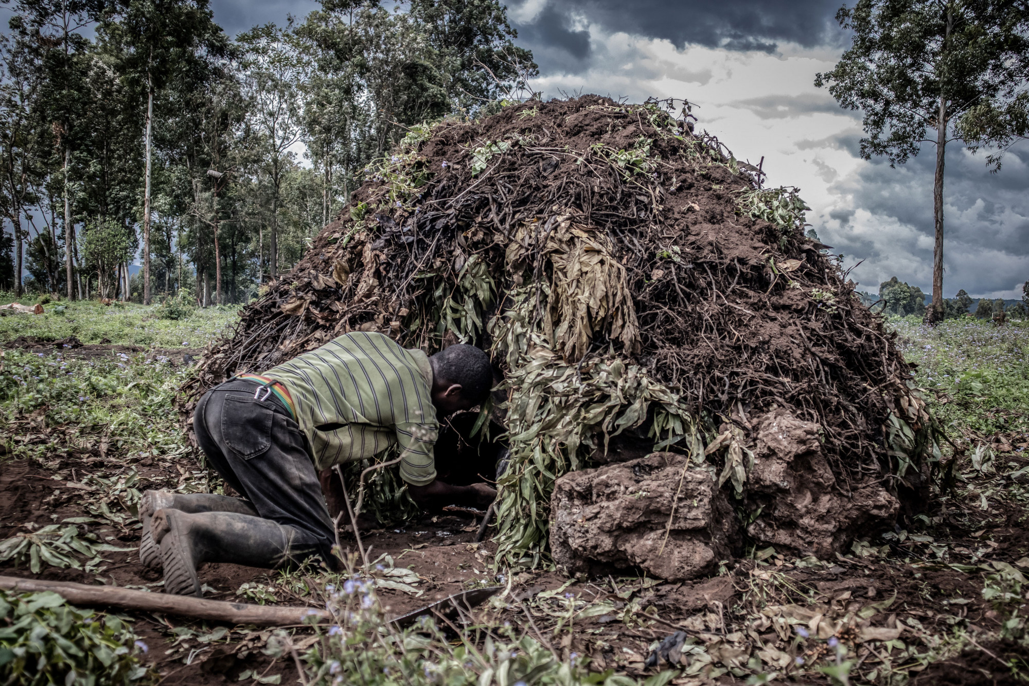 Parc national des Virunga, RDC, novembre 2020. Un père et son fils préparent un four pour produire du charbon de bois. © Guerchom Ndebo pour la Fondation Carmignac