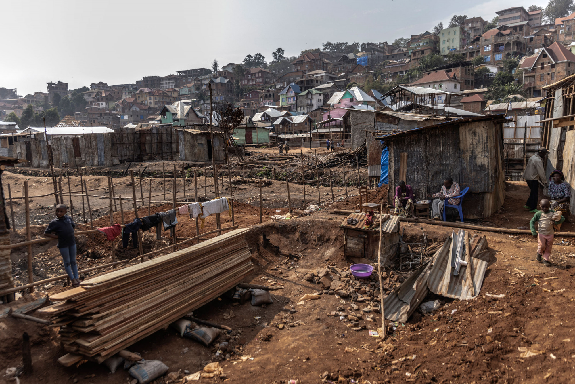 Bukavu, Sud-Kivu, 6 septembre 2021. Après un incendie qui a détruit au moins 400 maisons, la communauté essaie de reconstruire les maisons avec des planches. © Guerchom Ndebo pour la Fondation Carmignac.