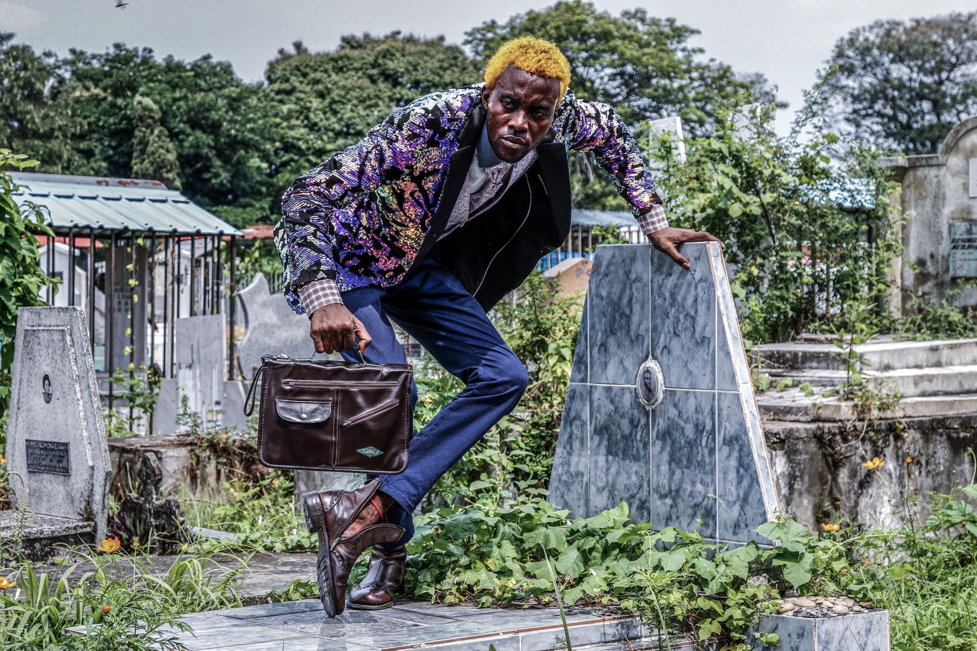 Kinshasa, RDC, 10 février 2021. Gael Basaul, qui se fait appeler « Nyarukos ba Forme », prend la pose sur une tombe du cimetière de la commune de Gombe. © Justin Makangara pour la Fondation Carmignac