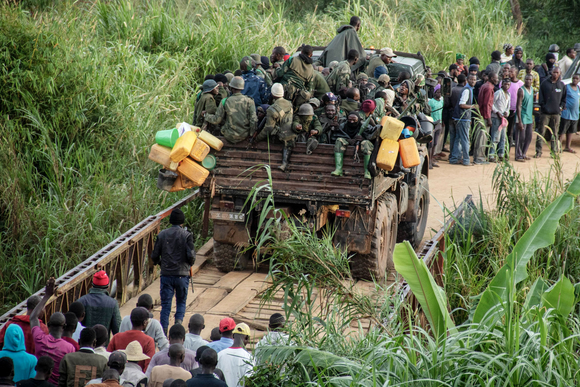 Nord-est de l’Ituri, RDC, avril 2020. À 15 km au nord de Bunia, un camion rempli de soldats gouvernementaux en route vers la ligne de front croise des villageois en fuite, lors d’affrontements avec des membres de la Coopérative pour le développement du Congo (Codeco), une secte politico-religieuse issue du groupe ethnique Lema. Des miliciens ont assassiné dans leur sommeil 22 personnes du village de Koli, toutes d’origine Hema, selon le témoignage de responsables de la ville de Djugu © Dieudonné Dirole pour la Fondation Carmignac