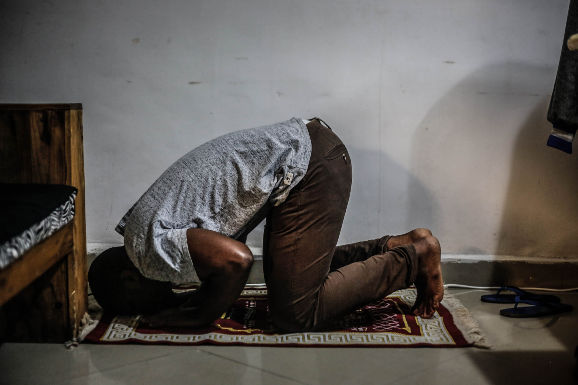 Goma, DRC, 2020. Unable to attend mosque to pray with others due to coronavirus restrictions, digital entrepreneur Ally Kahashi prays alone at home in his apartment in Goma. © Ley Uwera for Fondation Carmignac
